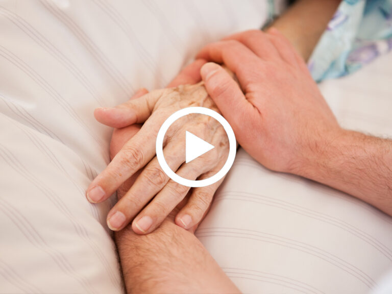 Videovorschaubild zu einem Podcast zum Thema Schmerz auf dem eine jüngere Person die Hand einer älteren Person hält.