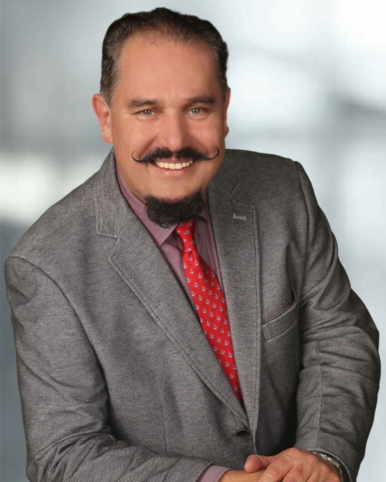 Portraitbild von Albin Wiesenhofer mit schwarzem Bart, grau-melierten Haaren und Jackett und roter Krawatte