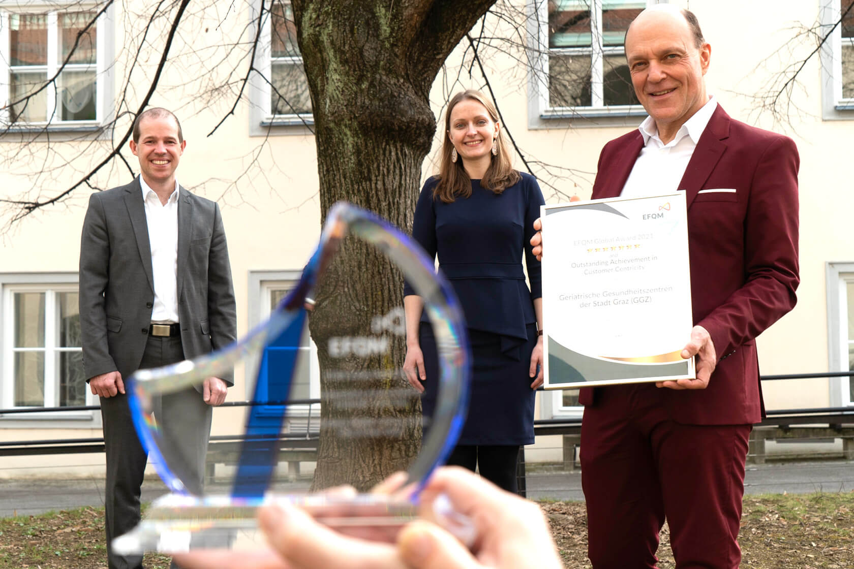 GGZ Geschäftsführer Gerd Hartinger mit Verena Matz und Martin Orehovec und der EFQM Global Awards Urkunde und dem Preis aus dem Jahr 2021