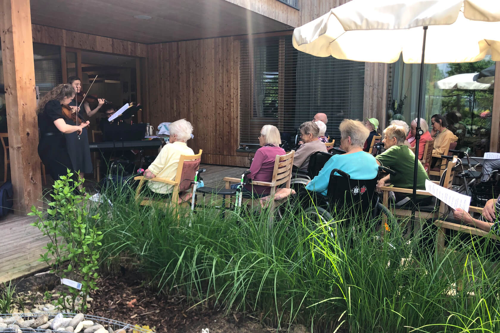 Klassisches Konzert im Außenbereich des Pflegewohnheims Peter Rosegger mit sitzenden Bewohner:innen