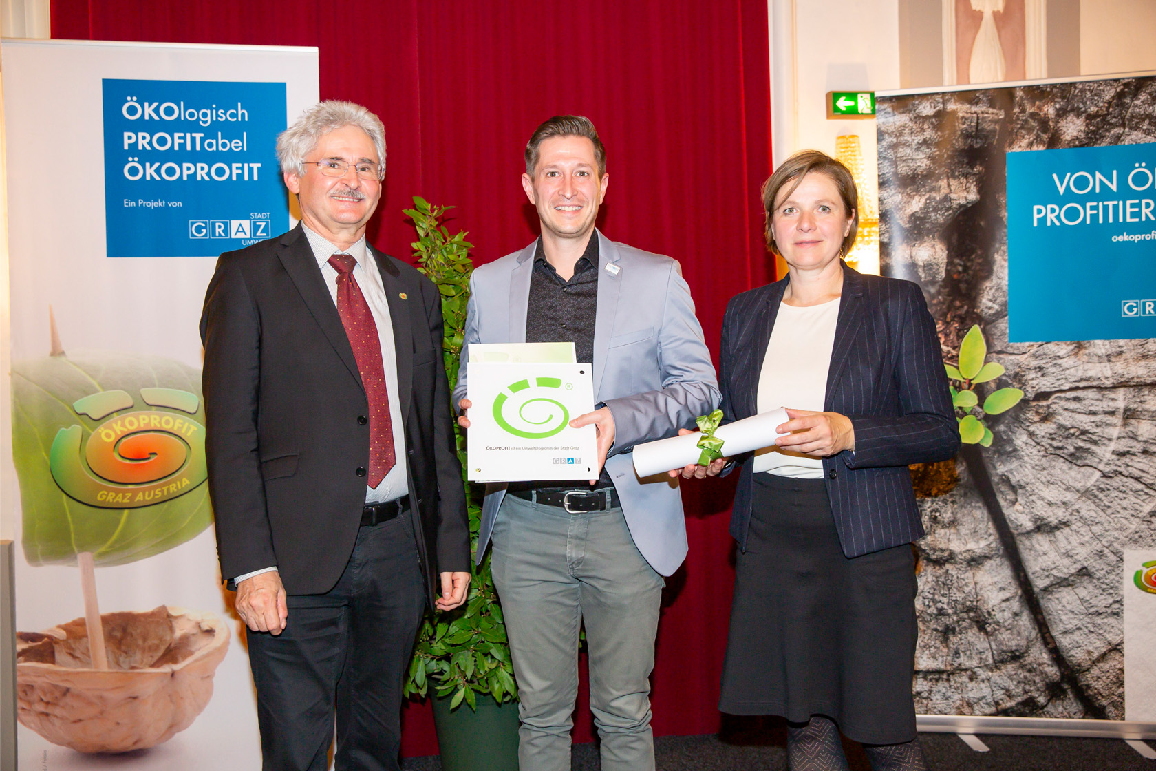 Übergabe der Ökoprofit Auszeichnung an Felix Homfeld durch einen Vertreter des Umweltamtes und Vizebürgermeisterin Schwentner.