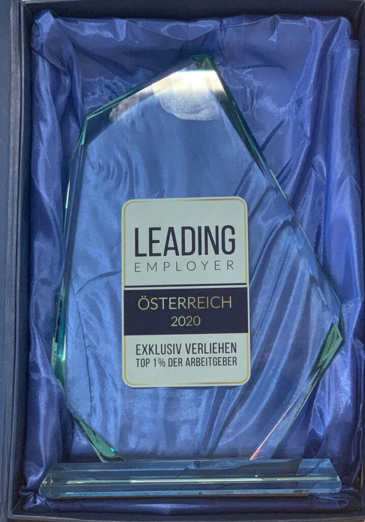 Glastrophäe für die Auszeichnung Leading Employer 2020 in blauer Box