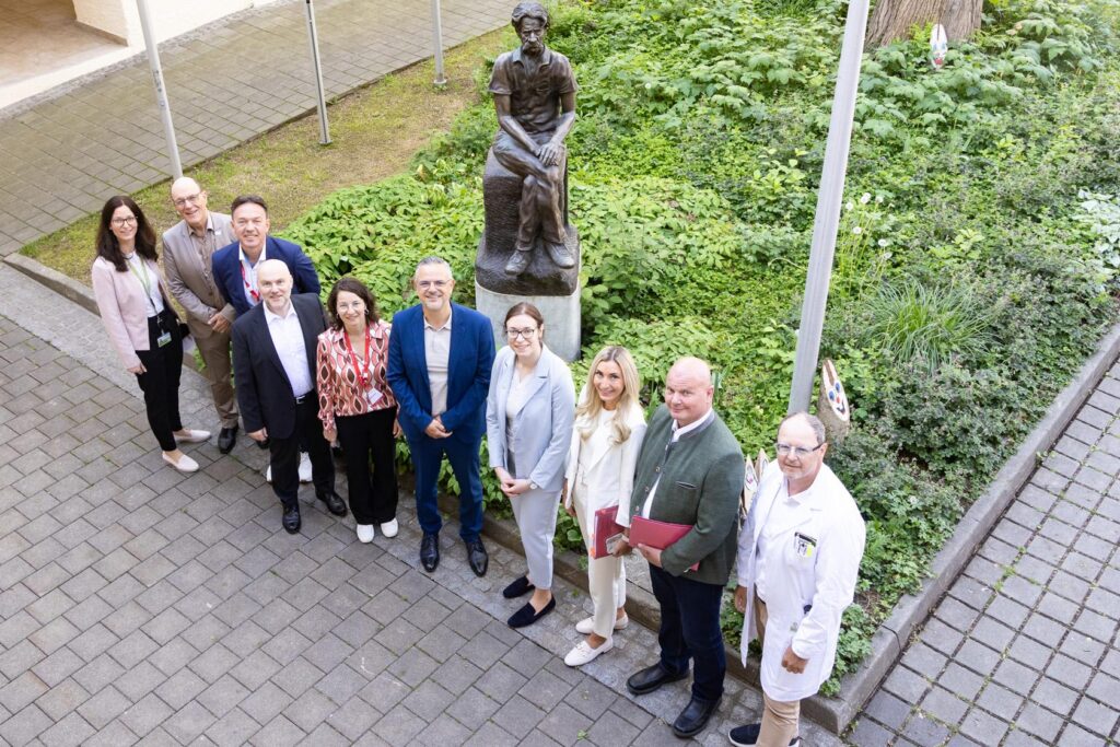 Gruppenbild der EFQM-Assessoren und Führungskräften der GGZ vor einer Albert Schweitzer Statue.